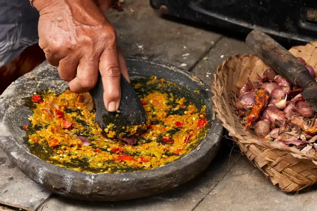 Category: D Traditional Balinese sambal being ground in stone mortar, PAON cookbook by Chef Wayan Kresna Yasa